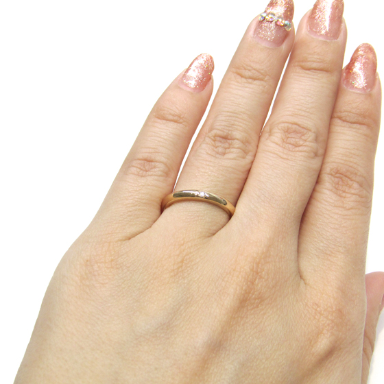 丸みを帯びたフォルムがキュートなデザイン。一粒ダイヤのシンプルな結婚指輪