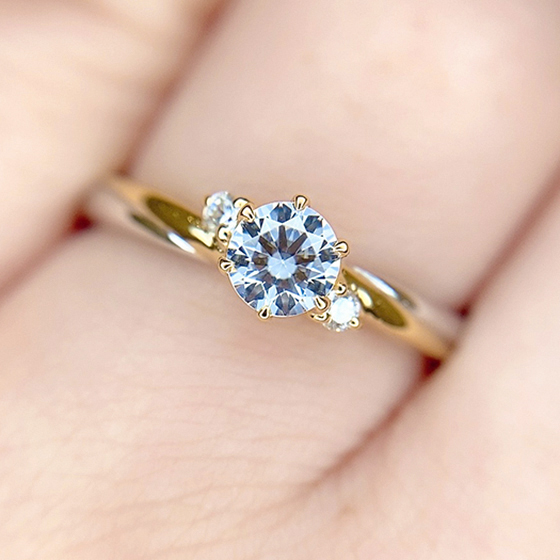 メインのダイヤモンドに花を添えるそうにセットされたサイドのメレダイヤモンドが可愛らしいデザイン。