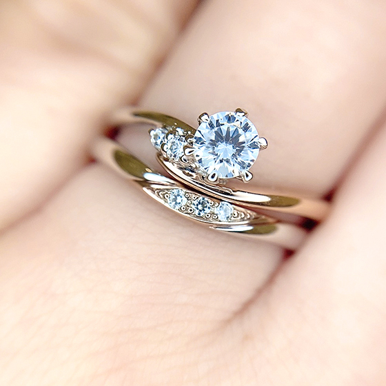 緩やかなカーブが寄り添うように重なる婚約指輪・結婚指輪のセットリング。