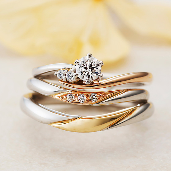 穏やかなカーブを描いた、コンビネーションタイプの結婚指輪とのセットリング。