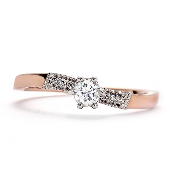 リボンを結んだようなキュートなデザインの婚約指輪。重なる結婚指輪もセットでご用意できます。