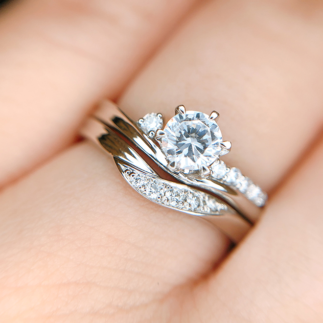 指の中央に婚約指輪のダイヤモンドが輝きます。まるでセットで1本のリングのような一体感があります。
