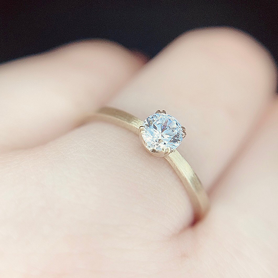 4本の華奢な爪でセットされた婚約指輪。シャープな印象が大人っぽい雰囲気に。