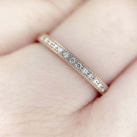 ゴージャスなエタニティセットのダイヤモンドと縁に加工されたミル打ちデザインが飽きることなく指元で輝きます。