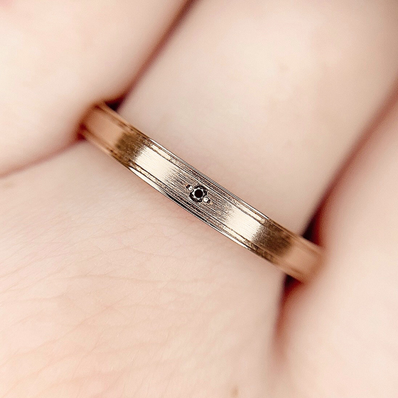 中央の小さめサイズのブラックダイヤモンドが特徴的な結婚指輪。さり気なく男性らしさがあるデザインです。