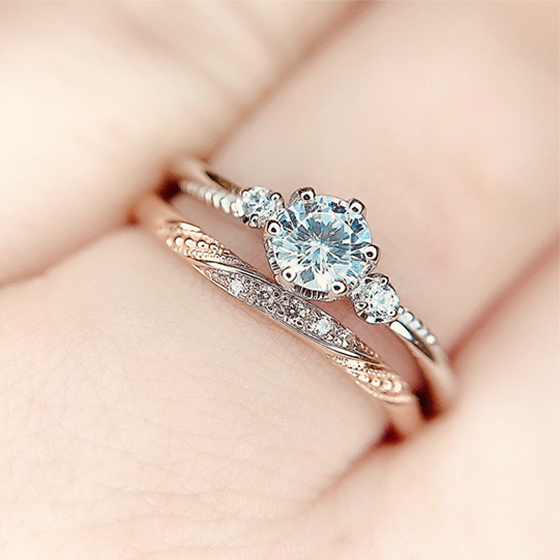 華奢な婚約指輪と結婚指輪のセットリング。繊細なミル打ち加工が女性に人気のデザインです。