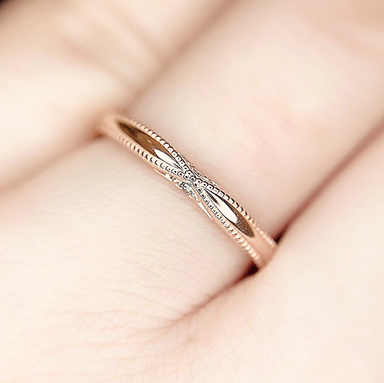 さり気なく中央に絞られたデザインが可愛らしい結婚指輪。