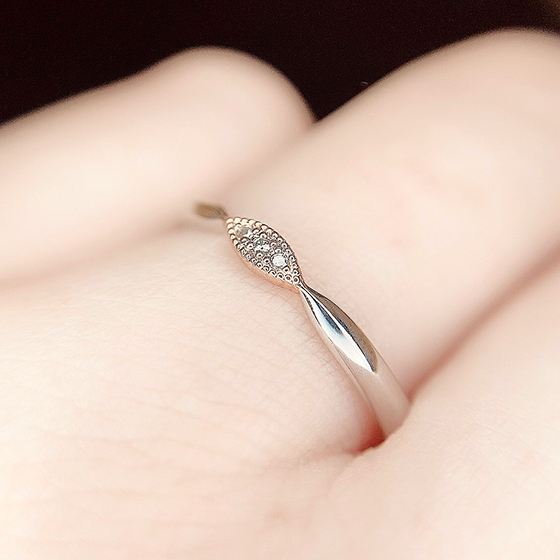 中央の丸みのあるデザインの縁にミル打ち加工を施した可愛らしい結婚指輪。