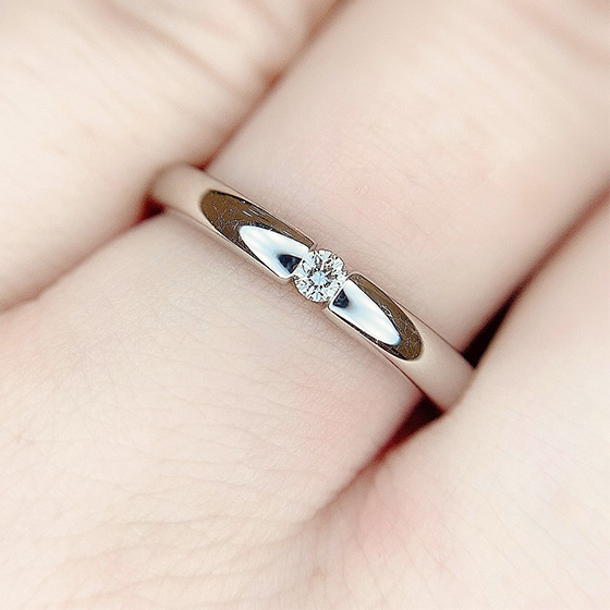 抱えられるように留められたダイヤモンドがかっこいい印象の結婚指輪です。