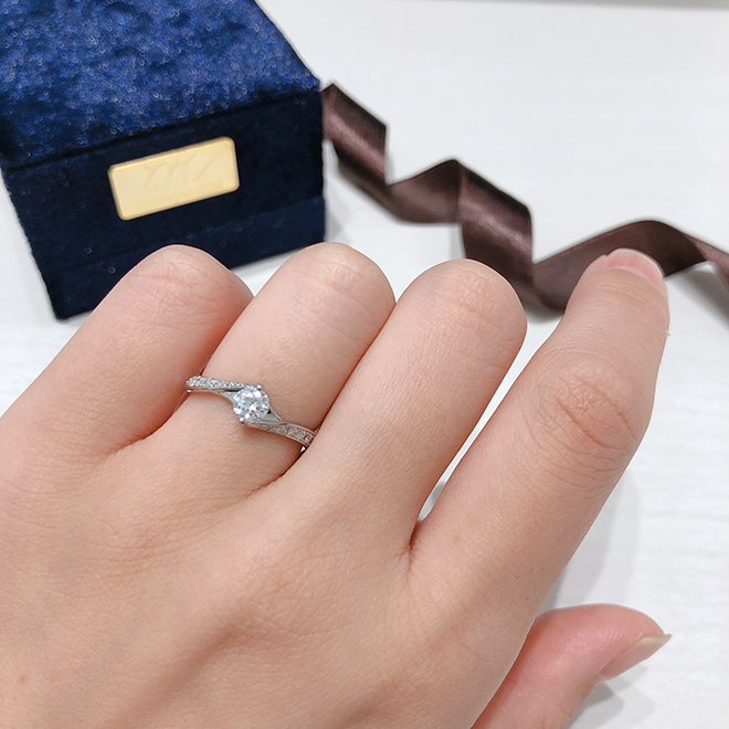 お指をきれいに見せてくれるSライン。両サイドに流れるようにダイヤモンドが輝く大人な印象の婚約指輪