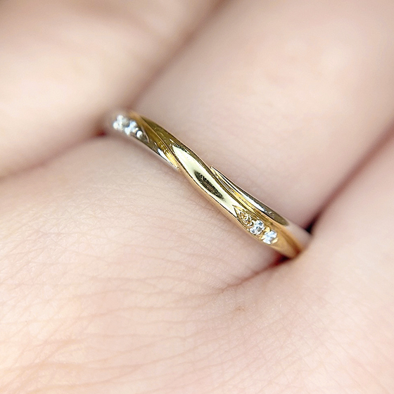 流れるラインが美しい結婚指輪。敢えてサイドにセットされたダイヤモンドがおしゃれ。