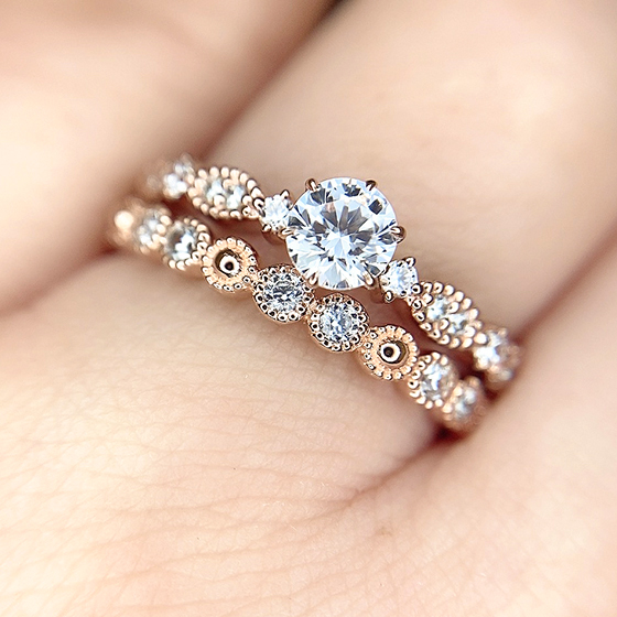 立体的なラウンド型とミル打ち加工が可愛らしい婚約指輪と結婚指輪のセットリング。