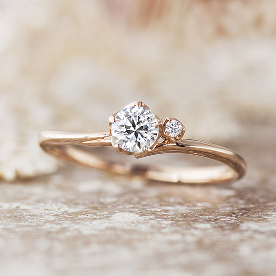 やわらかな曲線を描いた婚約指輪。ダイヤモンドを5点で留め、花弁のイメージをさせる婚約指輪。