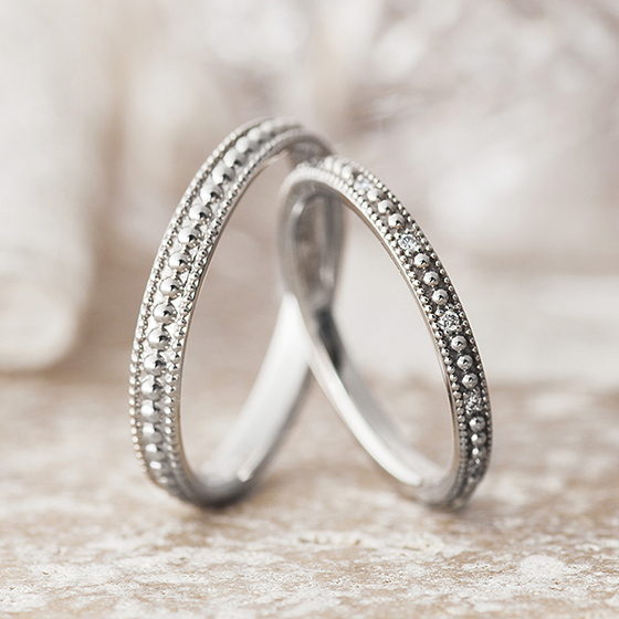 大小のミルグレインが一周に入っていて可愛い結婚指輪（マリッジリング）レディースにはさりげなくダイヤモンドが散りばめられています。
