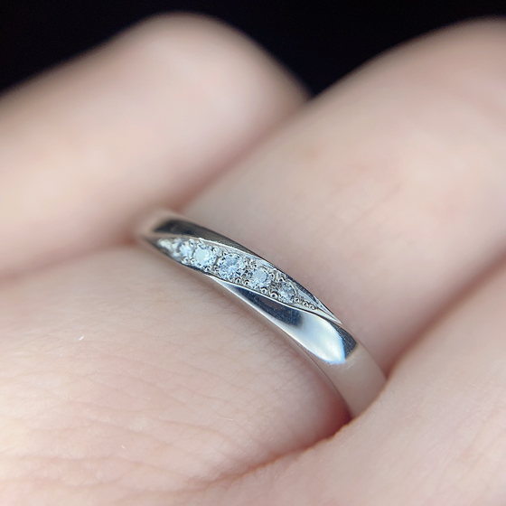 程よいボリューム感の結婚指輪（マリッジリング）。ダイヤモンドの斜めラインがフェミニンな印象に。