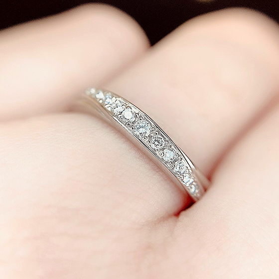 指の横にまで流れるダイヤモンドの輝きが美しいデザインです。