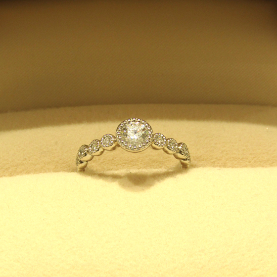 >メレダイヤが贅沢にあしらわれ、永遠・子宝・長寿などを意味するミルグレインが上品な婚約指輪です♪
