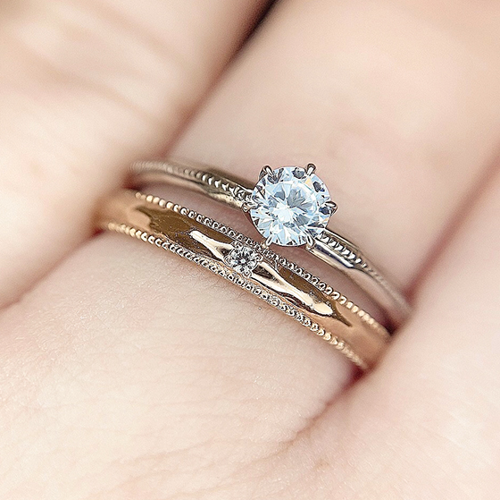 シンプルなストレートラインの婚約指輪と結婚指輪のセットリング。お揃いのミル打ち加工が上品でクラシカルな印象に仕上げてくれます。