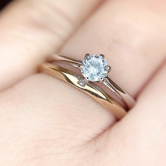 細身の幅で揃えた婚約指輪と結婚指輪のセットリング。緩やかに加工された槌目加工がポイントです