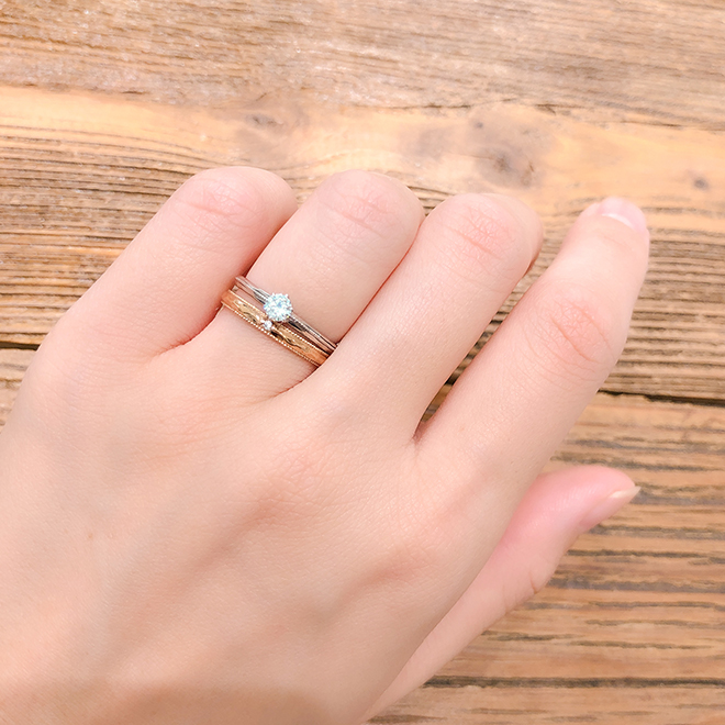 シンプルなストレートラインの婚約指輪と結婚指輪のセットリング。お揃いのミル打ち加工が上品でクラシカルな印象に仕上げてくれます。