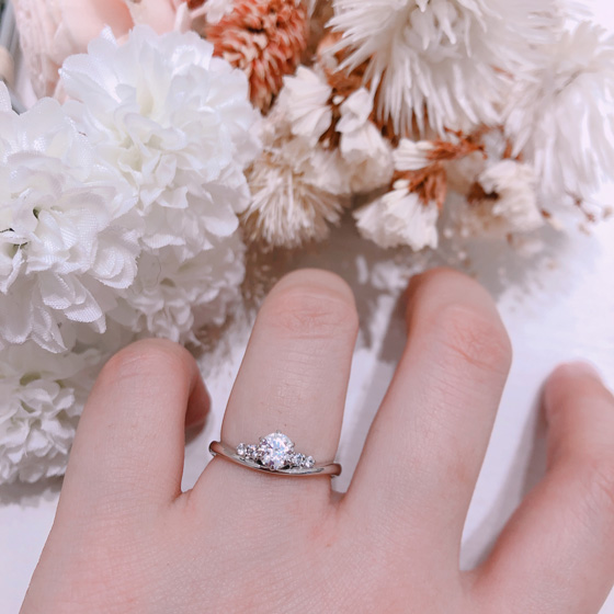 左右2石ずつメレダイヤモンドが並び、中心のダイヤモンドとラインになり存在感のあるデザインの婚約指輪（エンゲージリング）です。