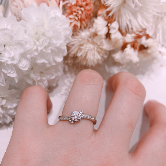 S字ウエーブがお指にフィットし、指輪のアームにはメレダイヤが贅沢に留められた華やかな婚約指輪。
