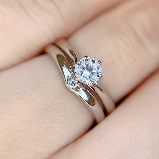 婚約指輪は中心に向かって絞られるアームで指をすっきり見せてくれます。V字の重なりがとっても美しいです。