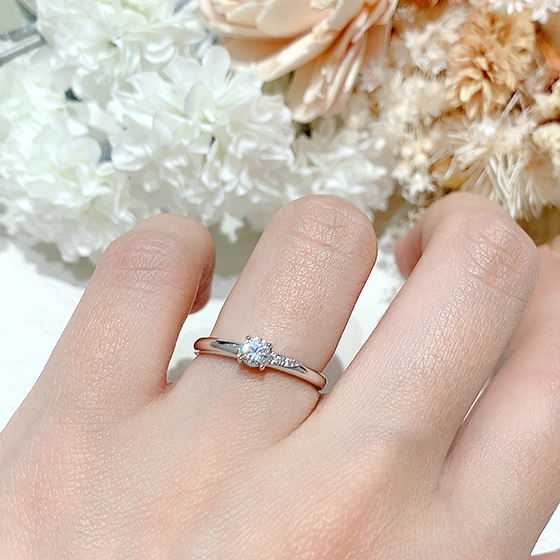 センターダイヤモンドから伸びるメレダイヤモンドのラインが美しい婚約指輪。