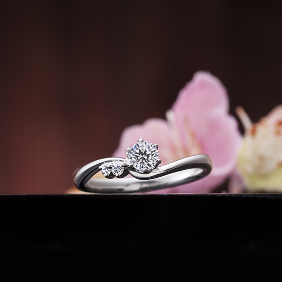 アームがセンターダイヤモンドを包み込む様に緩やかなSラインの婚約指輪（エンゲージリング）
