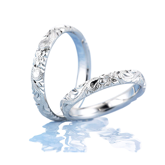 ふたりの結びつきを神様に誓うプルメリアとスクロールを組み合わせた結婚指輪（マリッジリング）