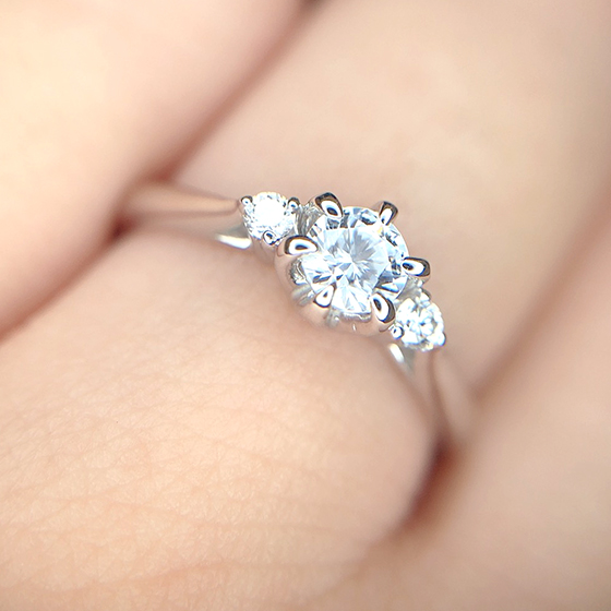 サイドに小さなメレダイヤモンドをセットされた婚約指輪。不動の人気デザインです。