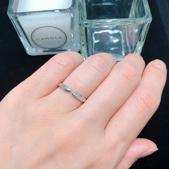 リボンモチーフのような結婚指輪。片側だけにあしらわれたダイヤモンドがおしゃれ。