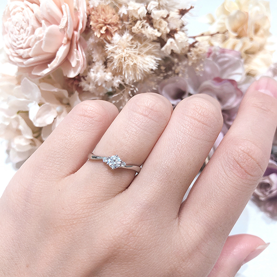 両サイドに一粒ずつあしらったメレダイヤが可愛らしさをアップ。婚約指輪らしいデザインです。