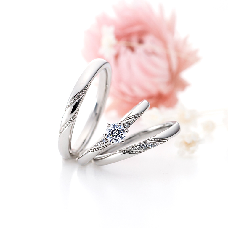 ミル打ちが華やかさを演出している婚約指輪と結婚指輪のセットリング