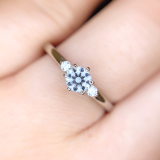 ダイヤモンドが引き立つように華奢でストレートな婚約指輪。両サイドにはグランバーガー社のメレダイヤモンドが輝きます