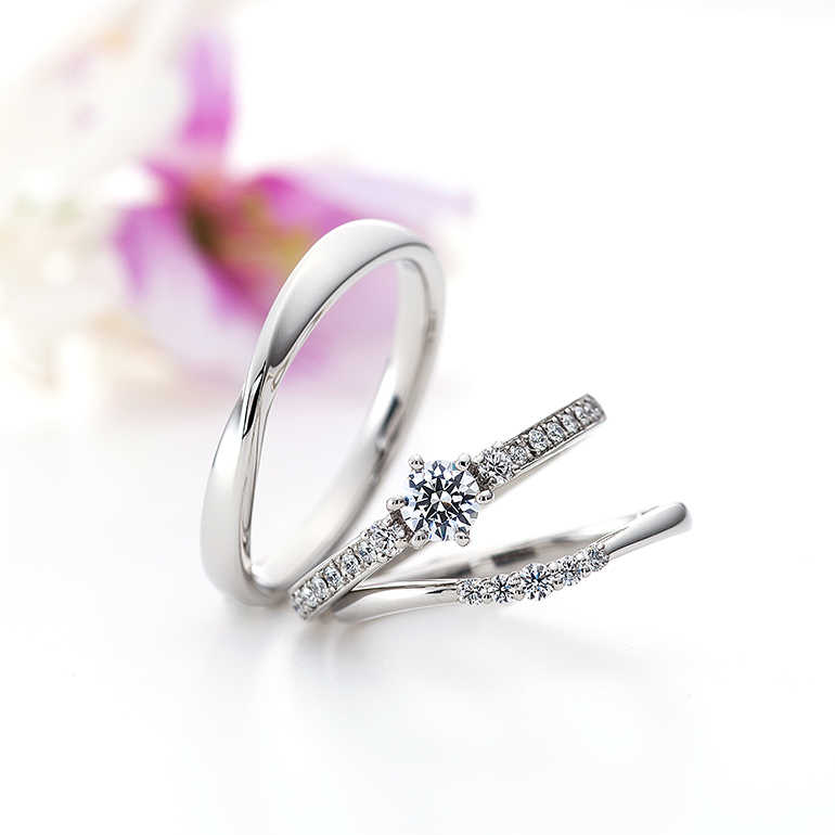 ハーフエタニティタイプのゴージャスな婚約指輪と華奢でシンプルな結婚指輪のセットリングです。