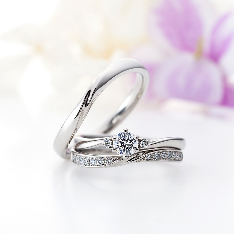 王道の婚約指輪にＳ字カーブが美しい結婚指輪とのセットリング。しなやかにダイヤモンドが輝きます。