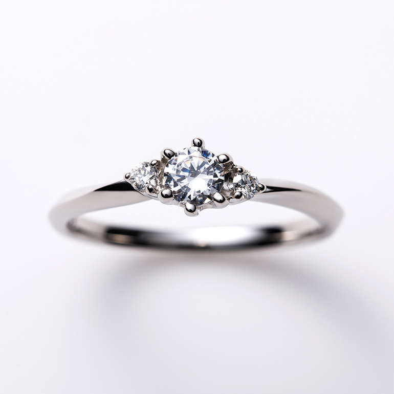 両サイドにメレダイヤモンドを留めることによりセンターダイヤモンドが引き立ちます。アーム部分の形状が特徴的な婚約指輪