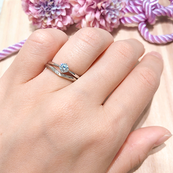 中央がくぼみ部分に婚約指輪のダイヤモンドがしっくりと収まるセットリング。