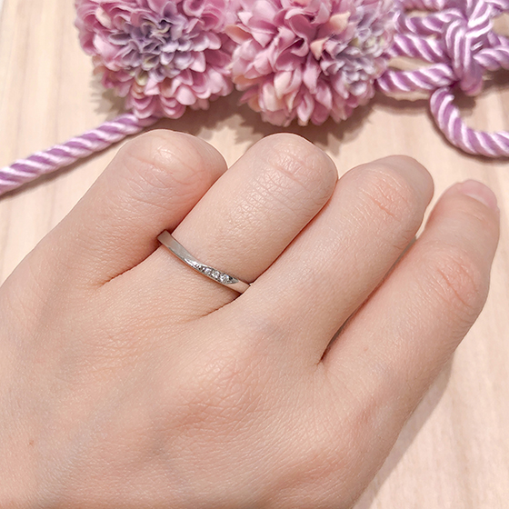 中心がねじれたお洒落なV字の結婚指輪。片方だけダイヤが入っているのがさりげなくて素敵。