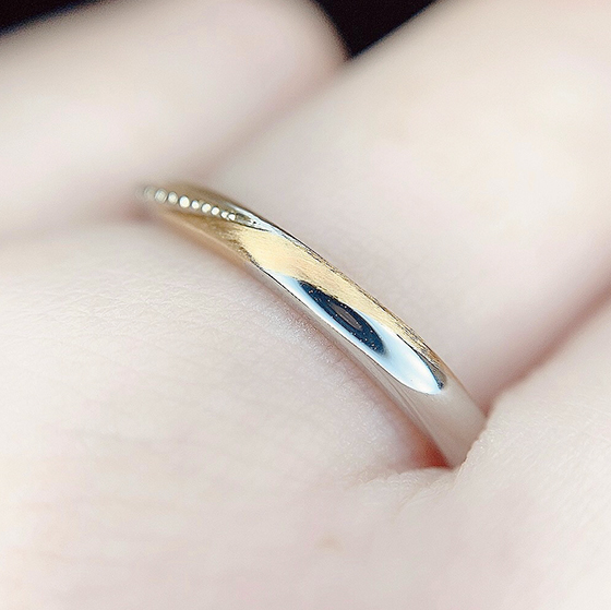 手の形状に沿って施されたゴールドがポイントの結婚指輪です。