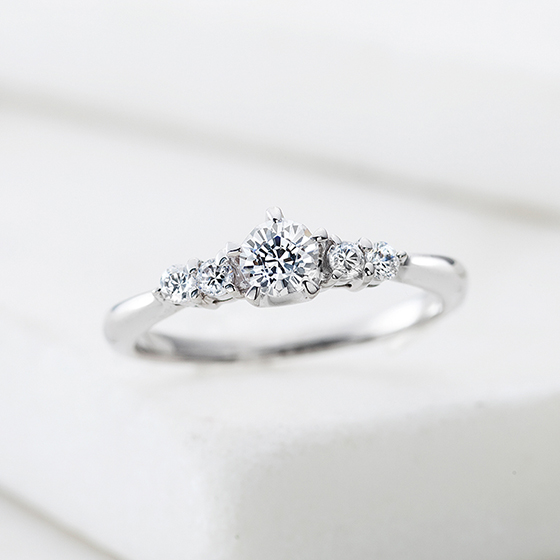 中心ダイヤのサイドに贅沢にメレダイヤをあしらい、ゴージャスな婚約指輪。