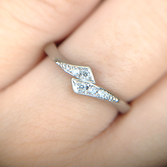 左右対称のモチーフが寄り添い重なり合うデザインが個性的で美しい結婚指輪。