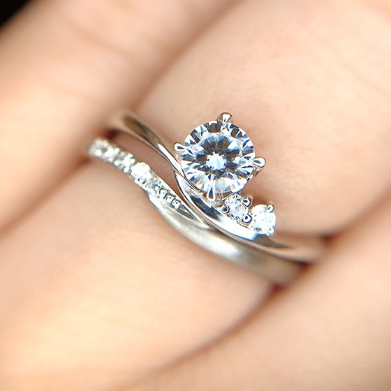 緩やかに動きのあるデザインで優しい印象の婚約指輪と結婚指輪のセットリング。