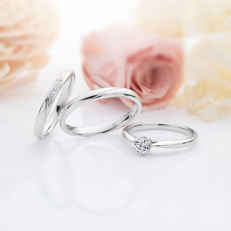 シンプルなストレートラインのセットリング婚約指輪は正統派な一粒タイプのエンゲージリング。マリッジリングは斜めにデザインを施した人気の結婚指輪です。