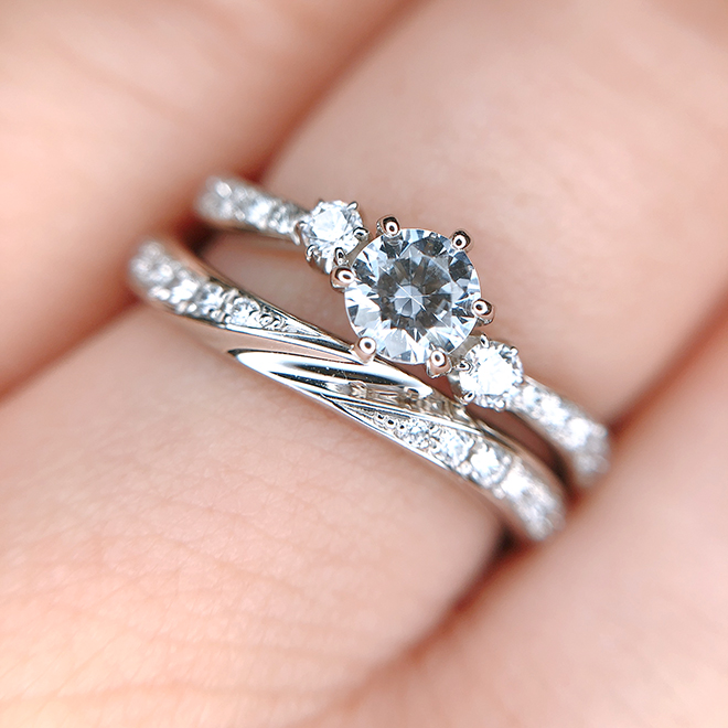 結婚指輪の中央のデザインと婚約指輪のダイヤモンドのコラボレーションが美しいデザイン。