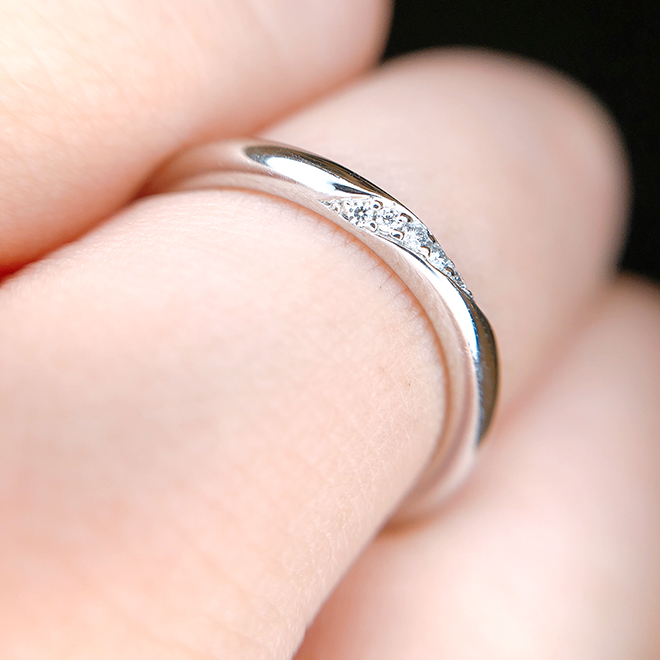 側面にかかり巻き付くように流れるダイヤモンドセッティングが美しい結婚指輪です