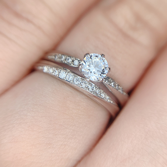 婚約指輪の大きなダイヤモンドの輝きと小さなメレダイヤモンドの細かい輝き、二つの輝きを堪能出来ます。