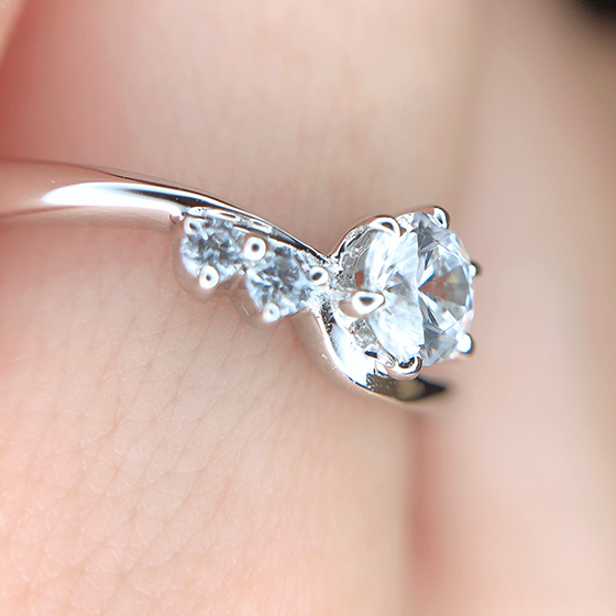 片側のみにセットされたメレダイヤモンドが可愛らしい婚約指輪。