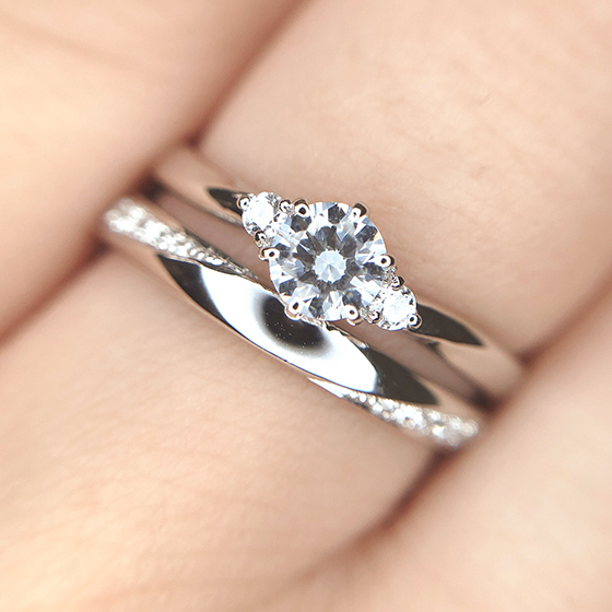 絶妙なバランスの婚約指輪と結婚指輪のセットリング。婚約指輪はセンター、結婚指輪はサイドにダイヤモンドの輝きをデザインしました。
